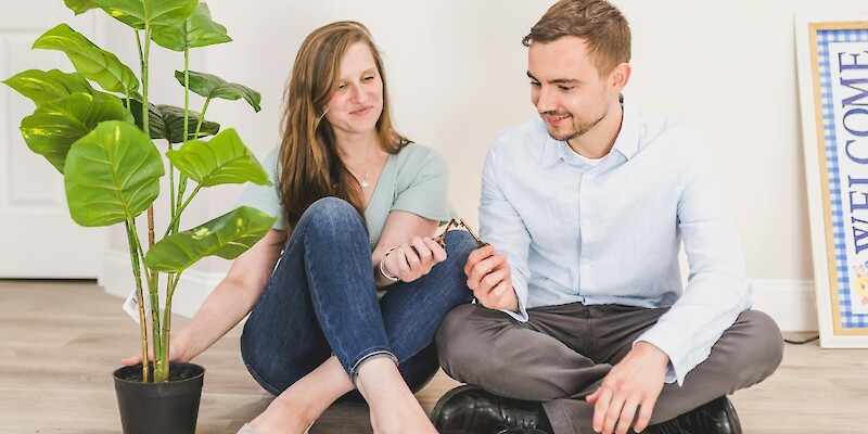 Man and Woman Sitting on the Floor while Holding Keys